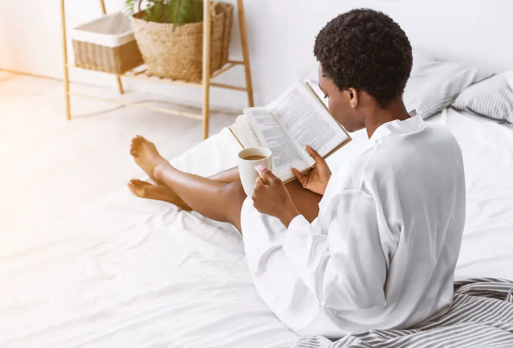Image of woman reading book, being a good mother means practicing  your own self-care